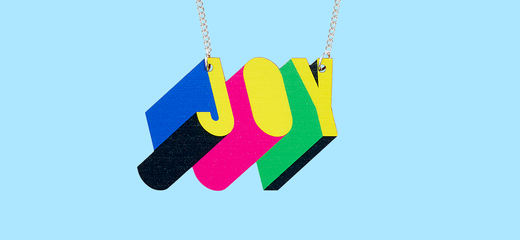 Tatty Devine X Morag Myerscough Joy Necklace against a blue background