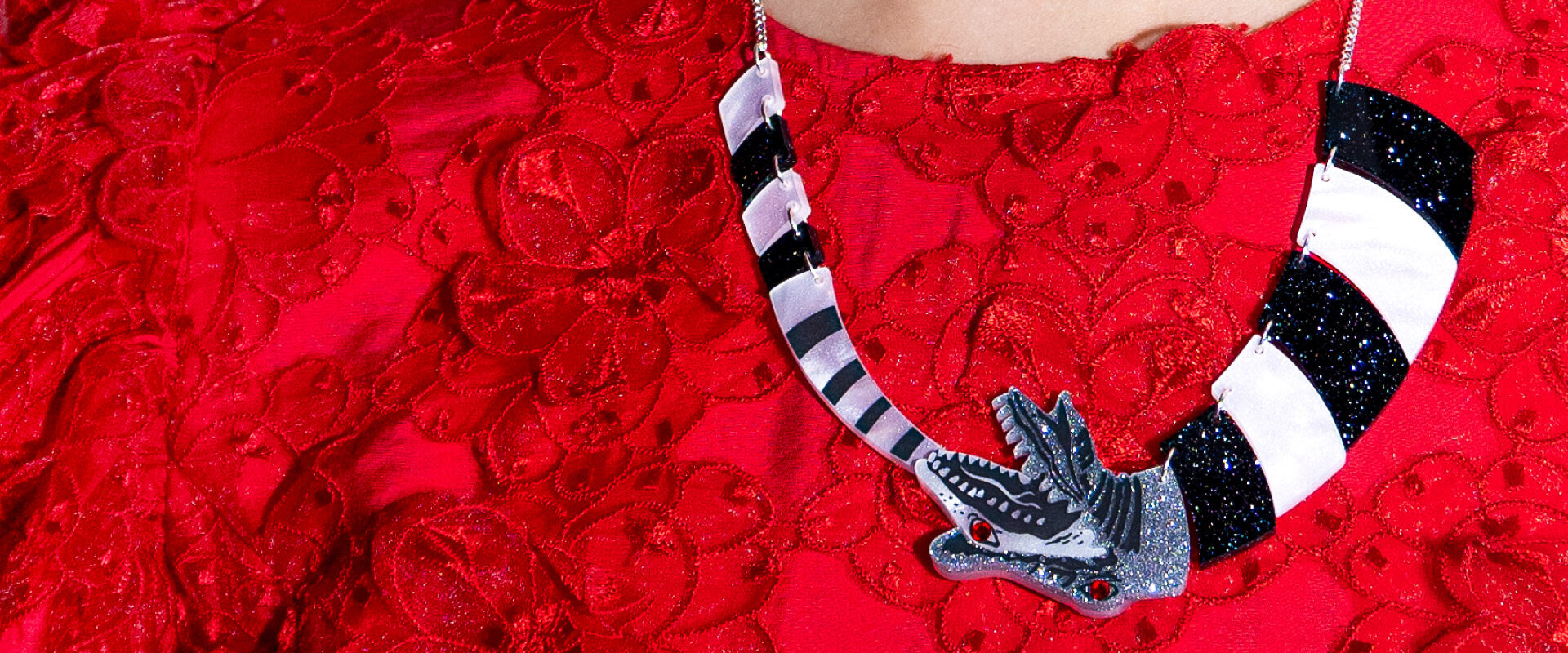 Beetlejuice X Tatty Devine Sandworm Necklace on a red lace top